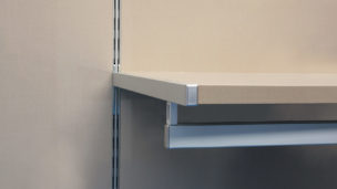 Attached to shelves hung on a vertical double slotted standards